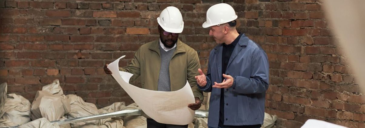 Two men discussing plans at a construction site